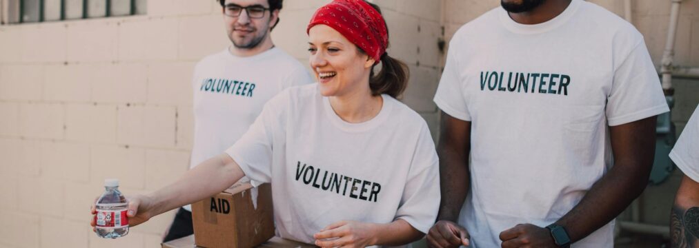 a group of charity volunteers standing next to supplies.